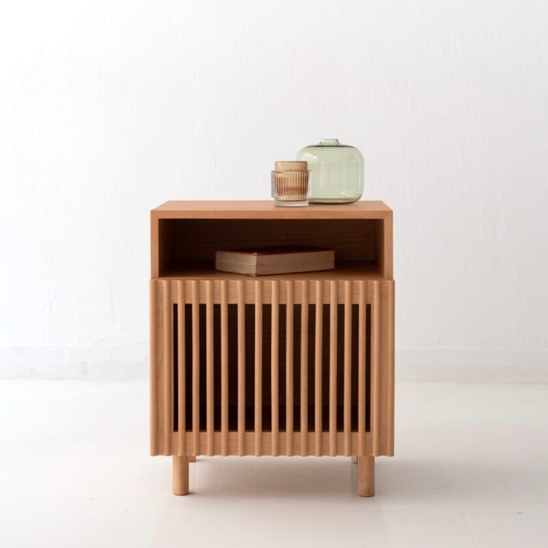 Small wooden nightstand with slatted front and open shelf on a white background