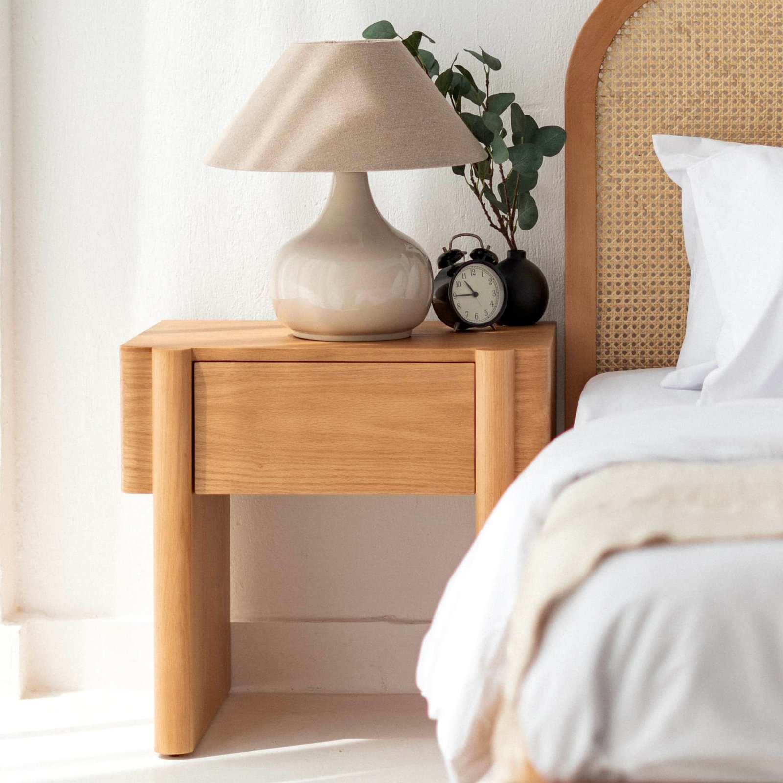 1 (4) Wooden bedside table next to a bed with table lamp and plant
